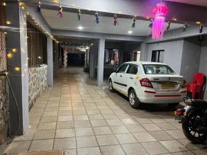 a white car parked in a garage with christmas lights at Savitri villa inn in Mahabaleshwar +2 photos