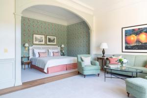 Un dormitorio con una cama, un sofá y una mesa. en Brenners Park Hotel & Spa, Oetker Hotels, en Baden-Baden