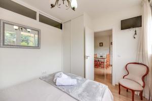 a white room with a bed and a chair at Piso cerca a la playa in Marbella