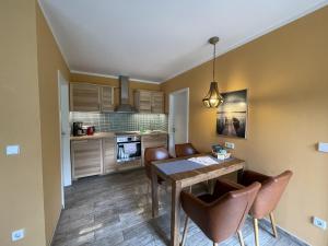 eine Küche mit Esstisch und Stühlen in der Unterkunft Ferienhaus Eichelhäher in Zossen