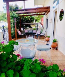 a patio with a table and chairs and flowers at Filoxenia in Choudetsi