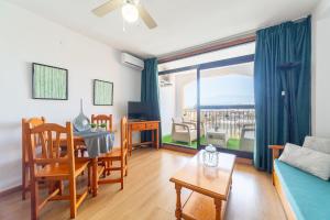 a living room with a couch and a table and a window at Apartamento residencial Fénix in Roquetas de Mar