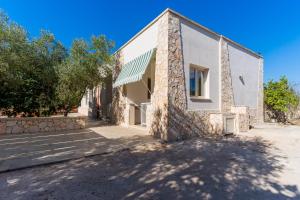 カストリニャーノ・デル・カーポにあるAppartamento Verde 1の正面に石壁と木々がある建物