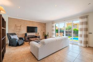 a living room with a white couch and a tv at Villa Joan Deia Escultor in Marratxí 