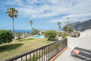 a balcony with a view of a pool and palm trees at Apartamento Acantilados in Acantilado de los Gigantes