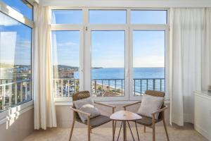 a room with two chairs and a table in front of windows at Penthouse studio with sea views in La Cala de Mijas