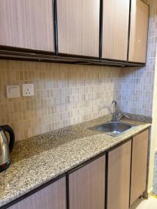 a kitchen with a sink and a counter top at فندق نزلي المعابدة in Miná