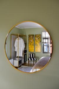a mirror reflecting a bedroom with a white shirt on a chair at Megaro Gioule in Siatista +7 photos