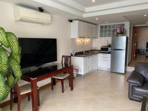 a living room with a table and a kitchen at Andaman Hill Pool Seaview in Patong Beach +15 photos