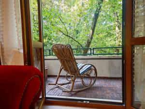 a rocking chair sitting on a porch looking out a window at B&b La Lucciola in Salsomaggiore Terme