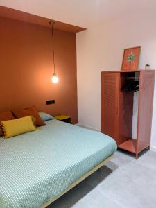 a bedroom with a bed and a wooden cabinet at El Taller de San Martín in Águilas