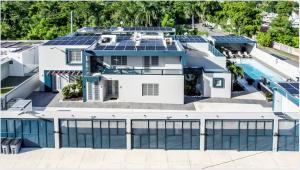 ドラドにあるAquaville Dorado Moderna Villa 5の屋根にソーラーパネルが設置された家の航空写真