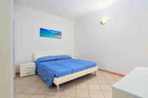 a bedroom with a bed with a blue blanket at Residence Orizzonti app n 23 in Golfo Aranci