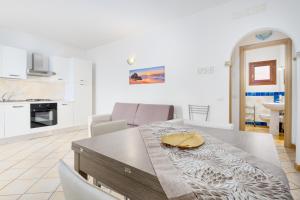 a kitchen and dining room with a table and chairs at Residence Orizzonti app n 23 in Golfo Aranci