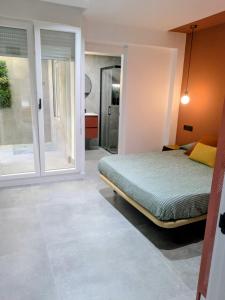 a bedroom with a bed and a sliding glass door at El Taller de San Martín in Águilas +38 photos