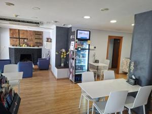 a room with tables and chairs and a refrigerator at Hotel 139 in Castelldefels