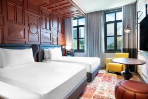 a hotel room with two beds and a table at Canopy By Hilton Istanbul Taksim in Istanbul
