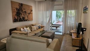 ein Wohnzimmer mit Sofa und Fernseher in der Unterkunft Family Retreat - Pool - Gym - BBQ - Walk to Beach in Cap Malheureux
