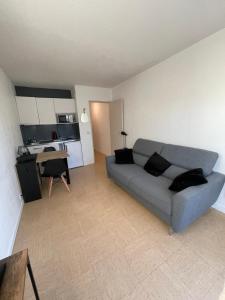 Una sala de estar con un sofá y una cocina. en Appartement Port d'Arcachon, en Arcachon
