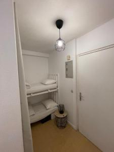 Una pequeña habitación con una litera y una luz. en Appartement Port d'Arcachon, en Arcachon