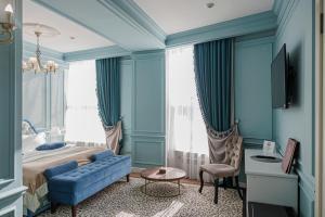 a blue bedroom with a bed and a blue couch at Royal BV in Ustʼ-Kamenogorsk