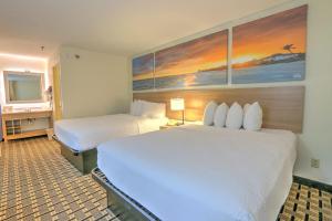 a hotel room with two beds and a television at Hotel Carolina Double Room - 2 Queen Beds in Hilton Head Island