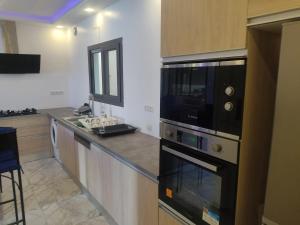 a kitchen with a stove and a microwave at Premium Villa in Ngaparou between Saly Somone in Ngaparou