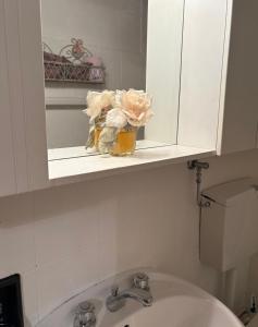 Un baño con lavabo, espejo e inodoro. en Nila's nest, en SantʼAnna Pelago