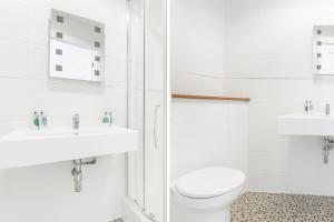 a white bathroom with a toilet and a sink at Russel Court Hotel Bournemouth Central in Bournemouth +61 photos