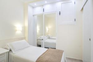 a white room with a bed and a mirror at Marina view modern apartment in Fuengirola