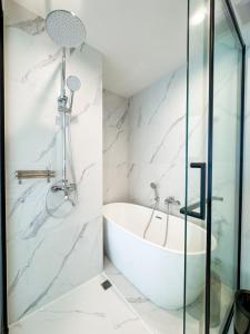 a bathroom with a tub and a glass shower at New Modern 1Bdr Laya 500 m to the Beach in Layan Beach +5 photos