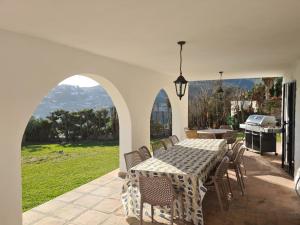 un patio avec une table, des chaises et un barbecue dans l'établissement Villa Las Dalias, à Almuñécar