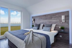 a bedroom with a large bed with a large window at Fewo Kapitän James Cook Olpenitz in Kappeln
