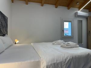 Un dormitorio blanco con una cama con toallas. en Welc-ōM Celeste Rooms, en Ponte di Brenta