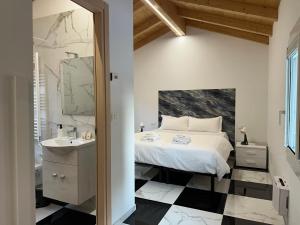 Un dormitorio con una cama y un baño con lavabo. en Welc-ōM Celeste Rooms, en Ponte di Brenta
