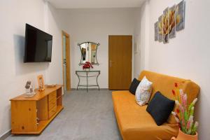 un salon avec un canapé et une télévision dans l'établissement Arinaga Home, à Arinaga