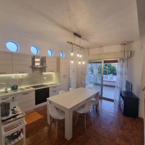 a kitchen with a white table and chairs in it at Fortezza Villa Azzurra in Agnone Bagni +35 photos