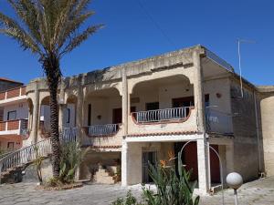 an old building with a palm tree in front of it at Fortezza Villa Azzurra in Agnone Bagni