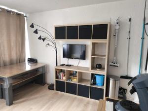 a room with a desk and a television on a shelf at Les Ours Bruns in Aragnouet