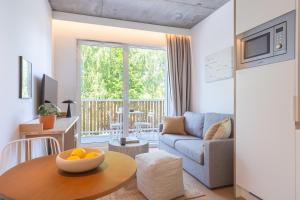 a living room with a couch and a table at BABEL COMMUNITY Hôtel Saint-Quentin-en-Yvelines in Montigny-le-Bretonneux
