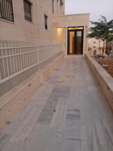 an empty sidewalk in front of a building at لا يمكن حجزه in Irbid