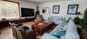 ein Wohnzimmer mit blauen Sofas und einem Fernseher in der Unterkunft Can di Luca in Malgrat de Mar