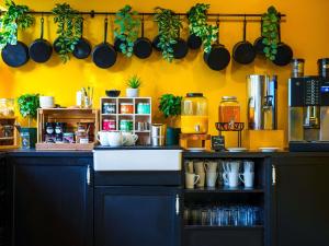 a kitchen with a counter with pots and pans on the wall at Novotel Saint Avold in Saint-Avold