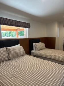 a room with two beds and a window at Kells Yard in Feevaghmore