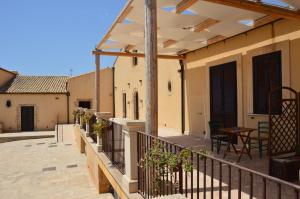 a balcony of a house with a table and chairs at Le Sorelle del Vino in Marzamemi