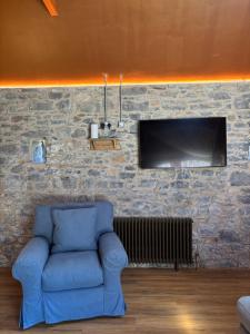 a living room with a blue couch and a tv at Kells Yard in Feevaghmore