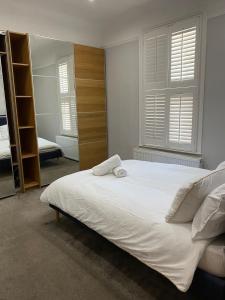 En eller flere senge i et værelse på Stylish 3-Bed Flat Opposite Central Line Station