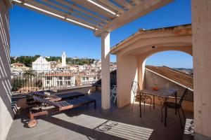 Un balcón con una mesa y vista a una ciudad. en Hora Est, en Orosei