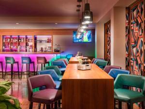 a bar with colorful chairs and a table in a room at Mercure Hotel Berlin City West in Berlin