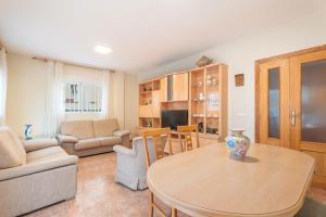 een woonkamer met een tafel en een bank bij Herba Sana in Cullera